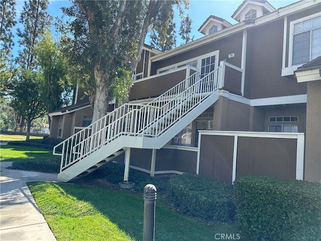 16521 Stonehaven Ct Unit 76, La Mirada, CA 90638 - view of property exterior with stairway, a lawn, and stucco siding