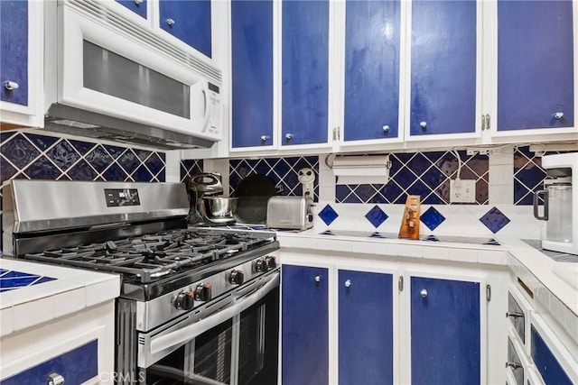 4900 E Chapman Ave Unit 102, Orange, CA 92869 - kitchen featuring stainless steel gas stove, white microwave, blue cabinets, and tile countertops