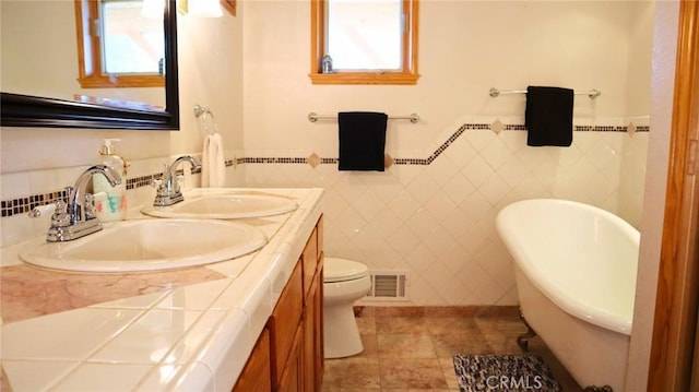 32455 Scandia Dr, Running Springs, CA 92382 - full bathroom featuring double vanity, a freestanding tub, tile walls, healthy amount of natural light, and tile patterned floors