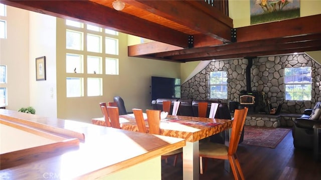 32455 Scandia Dr, Running Springs, CA 92382 - dining space with wood finished floors, beamed ceiling, a wood stove, and healthy amount of natural light
