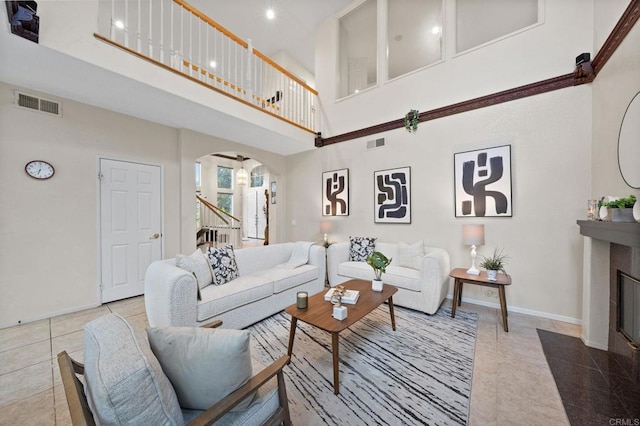 12032 Caneridge Rd, San Diego, CA 92128 - tiled living room with a towering ceiling, arched walkways, stairs, and a fireplace with flush hearth