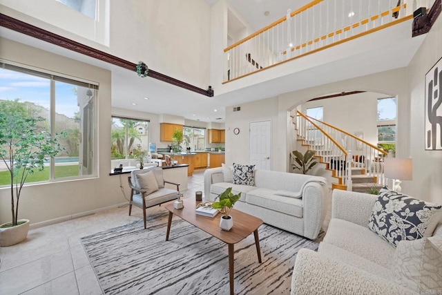 12032 Caneridge Rd, San Diego, CA 92128 - living area with stairs, arched walkways, a high ceiling, and light tile patterned floors