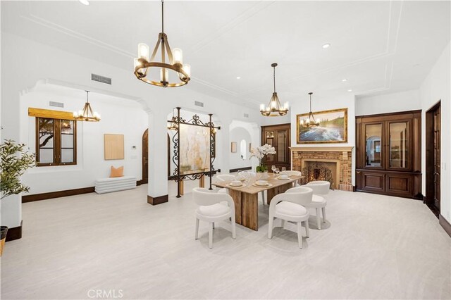 20 Cactus, Irvine, CA 92603 - dining space featuring a chandelier, arched walkways, baseboards, recessed lighting, and a warm lit fireplace