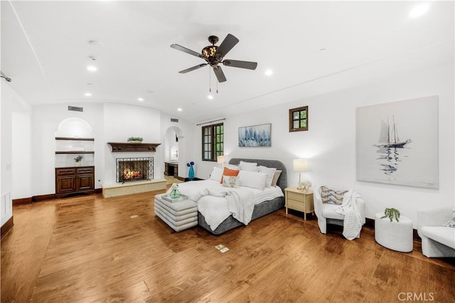 20 Cactus, Irvine, CA 92603 - bedroom featuring recessed lighting, lofted ceiling, a lit fireplace, wood finished floors, and arched walkways