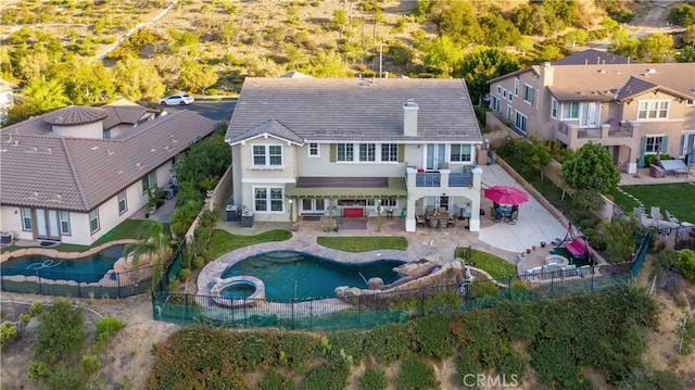 2514 Bulrush Cir, Corona, CA 92882 - rear view of house featuring a balcony, a fenced backyard, stucco siding, a pool with connected hot tub, and a patio area