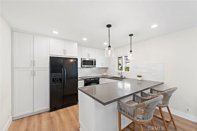 2175 S Coast Hwy Unit 16, Laguna Beach, CA 92651 - kitchen featuring black appliances, a sink, light wood-style flooring, a peninsula, and recessed lighting