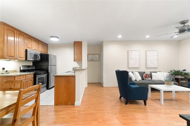 4727 W 147th St Unit 225, Lawndale, CA 90260 - kitchen with appliances with stainless steel finishes, light wood-style floors, light stone countertops, open floor plan, and recessed lighting