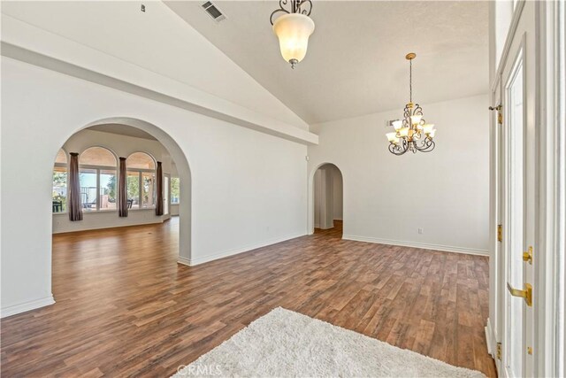 9098 Rattlesnake Rd, Phelan, CA 92371 - unfurnished room featuring arched walkways, a chandelier, wood finished floors, baseboards, and high vaulted ceiling