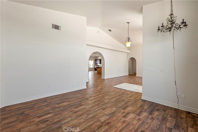 9098 Rattlesnake Rd, Phelan, CA 92371 - spare room featuring arched walkways, dark wood-type flooring, a chandelier, baseboards, and high vaulted ceiling