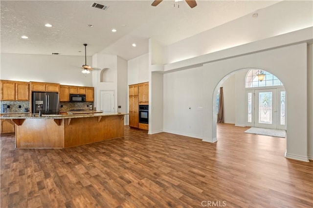 9098 Rattlesnake Rd, Phelan, CA 92371 - kitchen featuring black appliances, ceiling fan, arched walkways, high vaulted ceiling, and open floor plan