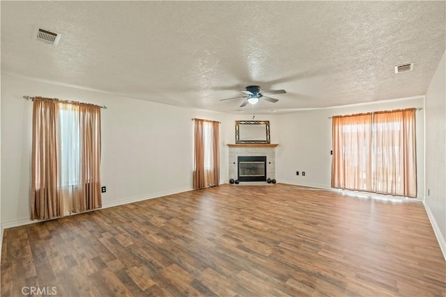 9098 Rattlesnake Rd, Phelan, CA 92371 - unfurnished living room featuring ceiling fan, wood finished floors, a textured ceiling, a tiled fireplace, and baseboards
