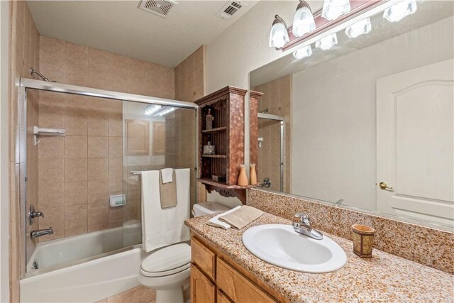 9098 Rattlesnake Rd, Phelan, CA 92371 - bathroom with vanity, toilet, shower / bath combination with glass door, and tile patterned floors