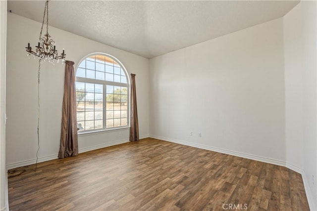 9098 Rattlesnake Rd, Phelan, CA 92371 - unfurnished room featuring a chandelier, wood finished floors, plenty of natural light, baseboards, and a textured ceiling