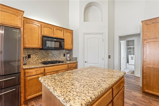 9098 Rattlesnake Rd, Phelan, CA 92371 - kitchen featuring freestanding refrigerator, black microwave, a towering ceiling, decorative backsplash, and dark wood-style floors