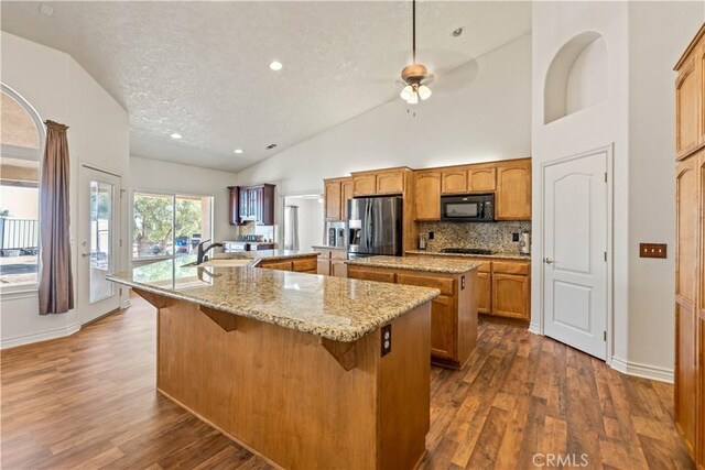 9098 Rattlesnake Rd, Phelan, CA 92371 - kitchen with a large island, black appliances, a ceiling fan, a sink, and dark wood finished floors