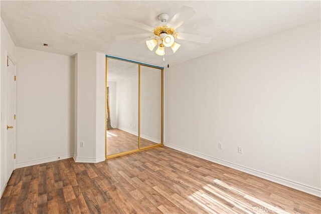9098 Rattlesnake Rd, Phelan, CA 92371 - unfurnished bedroom with wood finished floors, a closet, baseboards, and a ceiling fan