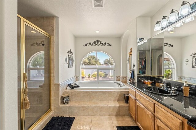 9098 Rattlesnake Rd, Phelan, CA 92371 - full bathroom with a stall shower, a bath, tile patterned floors, vanity, and a textured ceiling