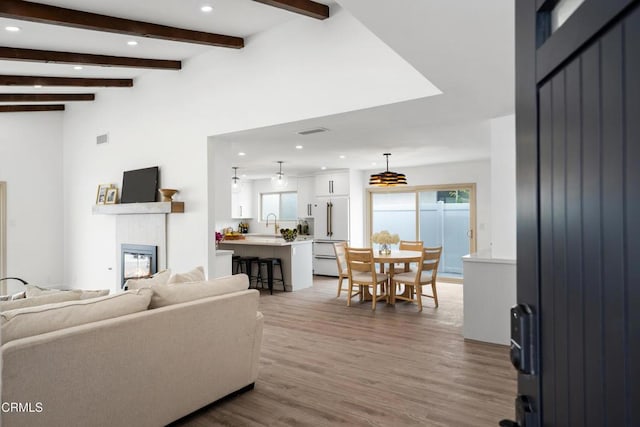 4834 Island View St, Oxnard, CA 93035 - living area featuring wood finished floors, recessed lighting, a glass covered fireplace, and beam ceiling