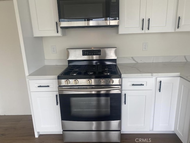 44516 La Paz Rd, Temecula, CA 92592 - kitchen with appliances with stainless steel finishes, white cabinets, light stone counters, and dark wood-type flooring