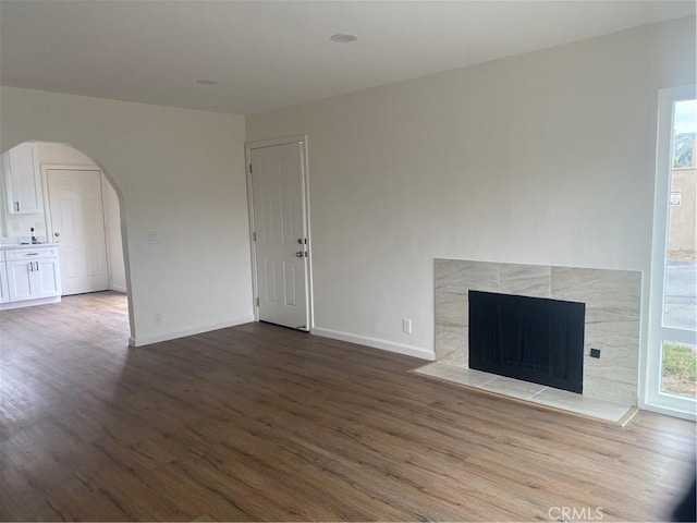 44516 La Paz Rd, Temecula, CA 92592 - unfurnished living room with wood finished floors, arched walkways, and a tile fireplace