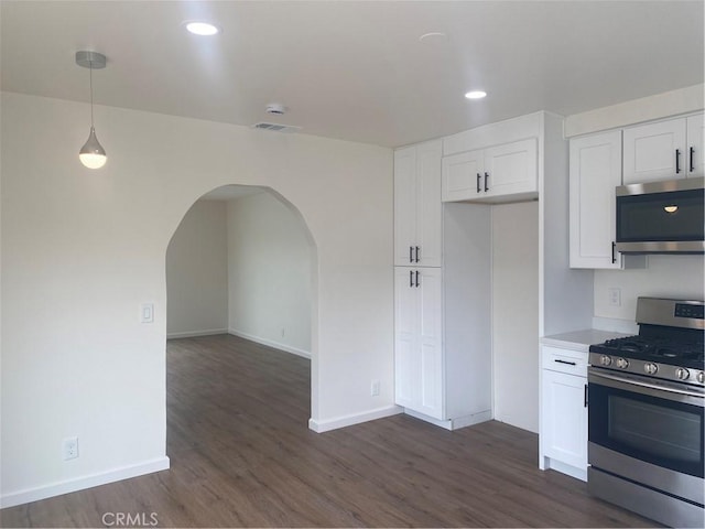 44516 La Paz Rd, Temecula, CA 92592 - kitchen featuring appliances with stainless steel finishes, arched walkways, dark wood-style floors, white cabinetry, and hanging light fixtures