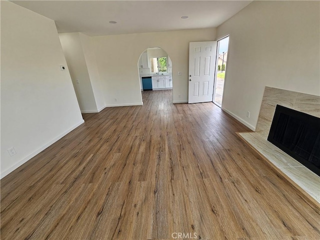 44516 La Paz Rd, Temecula, CA 92592 - unfurnished living room with arched walkways, wood finished floors, and a high end fireplace