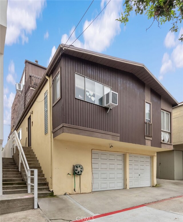 445 Longfellow Ave, Hermosa Beach, CA 90254 - view of front of property featuring stairs, concrete driveway, a garage, stucco siding, and cooling unit