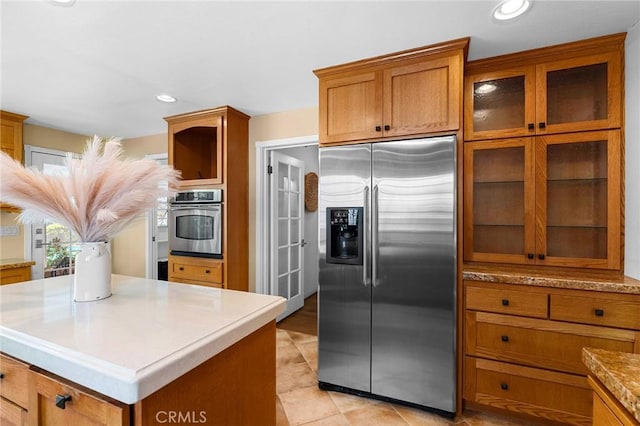 1539 Hammon Ave, Oroville, CA 95966 - kitchen featuring stainless steel appliances, brown cabinets, glass insert cabinets, a kitchen island, and recessed lighting