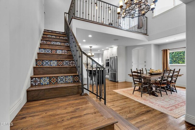 171 N Sunset Pl, Monrovia, CA 91016 - stairway featuring a chandelier, wood finished floors, a towering ceiling, and recessed lighting