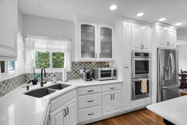 171 N Sunset Pl, Monrovia, CA 91016 - kitchen with appliances with stainless steel finishes, white cabinetry, decorative backsplash, glass insert cabinets, and recessed lighting