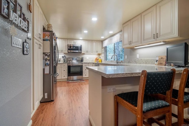 8516 Valley View Trl, Pine Valley, CA 91962 - kitchen featuring stainless steel appliances, a peninsula, light wood-type flooring, recessed lighting, and a breakfast bar
