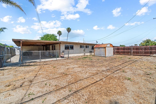 374 Will Ave, Oxnard, CA 93036 - back of property featuring a storage shed, a fenced backyard, stucco siding, and an attached carport