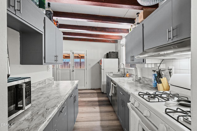 374 Will Ave, Oxnard, CA 93036 - kitchen with appliances with stainless steel finishes, under cabinet range hood, gray cabinets, wood finished floors, and beamed ceiling