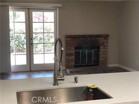 3249 Cambridge Dr, Chino Hills, CA 91709 - unfurnished living room featuring a sink, french doors, healthy amount of natural light, and a brick fireplace