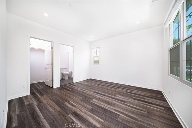 102 Anthology, Irvine, CA 92618 - unfurnished bedroom featuring multiple windows, dark wood finished floors, a walk in closet, baseboards, and recessed lighting