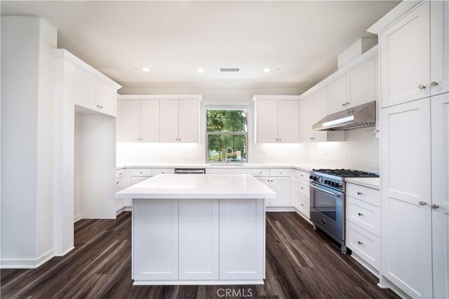 102 Anthology, Irvine, CA 92618 - kitchen with under cabinet range hood, high end stove, a sink, dark wood finished floors, and white cabinets