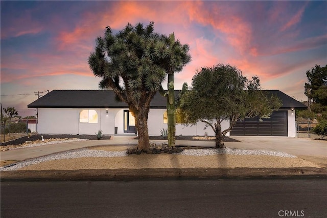 7495 Balsa Ave, Yucca Valley, CA 92284 - view of front facade featuring concrete driveway, stucco siding, and a garage