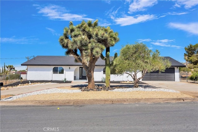 7495 Balsa Ave, Yucca Valley, CA 92284 - view of front of home with driveway, a garage, and stucco siding
