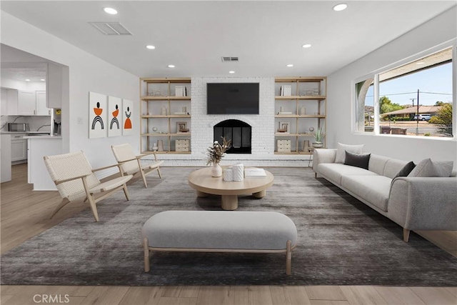 7495 Balsa Ave, Yucca Valley, CA 92284 - living area with recessed lighting, wood finished floors, a brick fireplace, and built in features