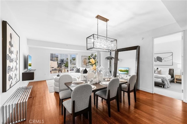 6250 Hollywood Blvd Unit 7G, Los Angeles, CA 90028 - dining area featuring wood finished floors, a chandelier, and baseboards