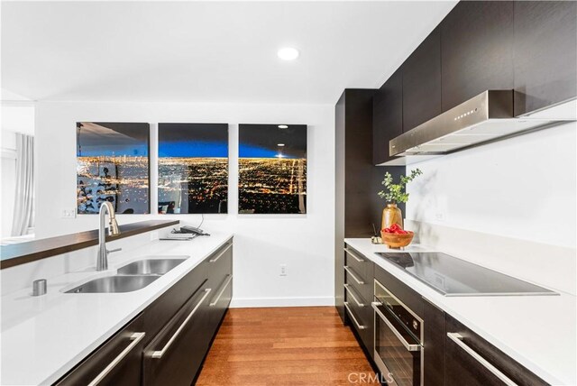 6250 Hollywood Blvd Unit 7G, Los Angeles, CA 90028 - kitchen with stainless steel oven, black electric stovetop, a sink, light wood-style flooring, and light countertops