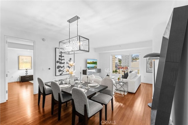6250 Hollywood Blvd Unit 7G, Los Angeles, CA 90028 - dining room featuring a chandelier, wood finished floors, and baseboards