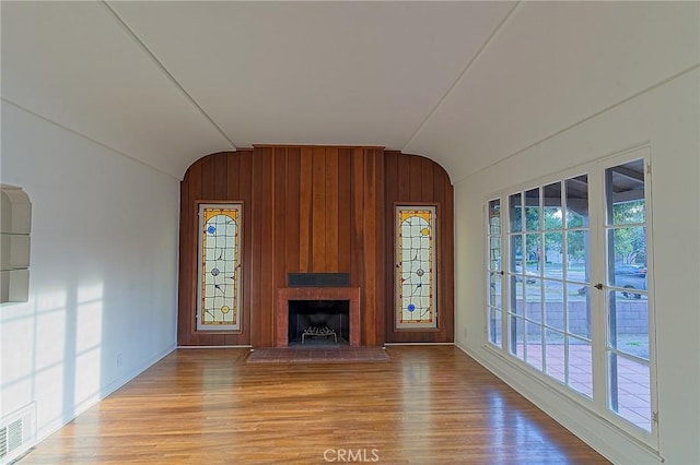 550 N 1st Ave, Upland, CA 91786 - unfurnished living room featuring lofted ceiling, wood finished floors, healthy amount of natural light, a large fireplace, and wood walls
