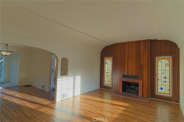 550 N 1st Ave, Upland, CA 91786 - unfurnished living room featuring vaulted ceiling, arched walkways, wood finished floors, healthy amount of natural light, and a brick fireplace