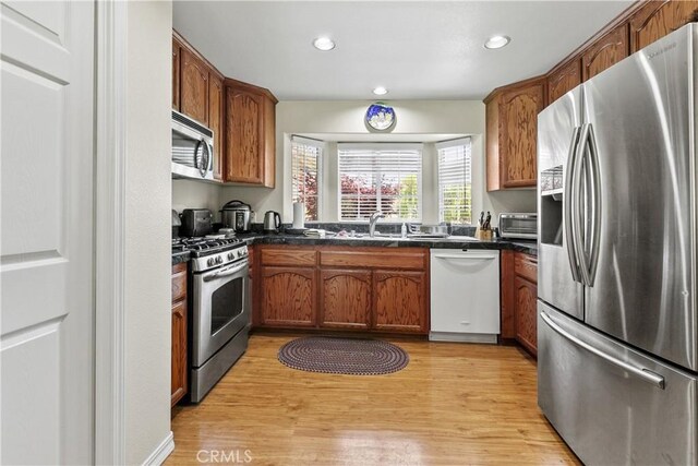 1350 Cardo Way, Nipomo, CA 93444 - kitchen featuring stainless steel appliances, dark countertops, light wood-type flooring, recessed lighting, and a sink