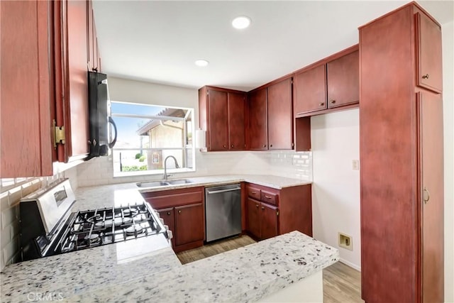 27057 Rangewood St, Menifee, CA 92586 - kitchen featuring stainless steel appliances, a sink, light countertops, light wood finished floors, and decorative backsplash