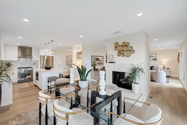 2817 San Ramon Dr, Rancho Palos Verdes, CA 90275 - dining area featuring light wood-style floors, a premium fireplace, recessed lighting, and baseboards
