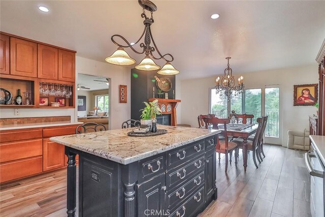 240 Portal St, Oak View, CA 93022 - kitchen featuring dark cabinetry, a chandelier, a center island, light wood-style floors, and hanging light fixtures