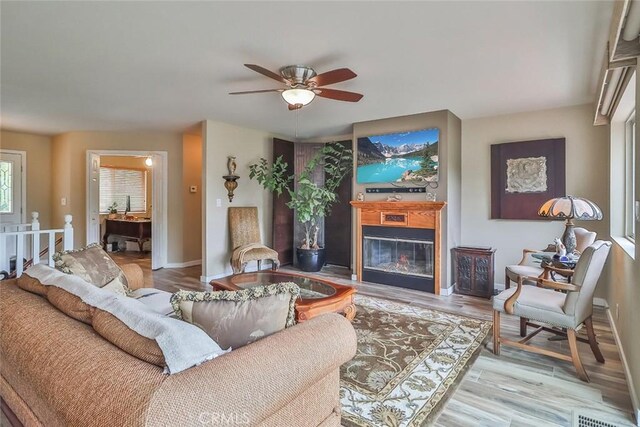 240 Portal St, Oak View, CA 93022 - living area with a glass covered fireplace, a ceiling fan, light wood-style floors, and baseboards