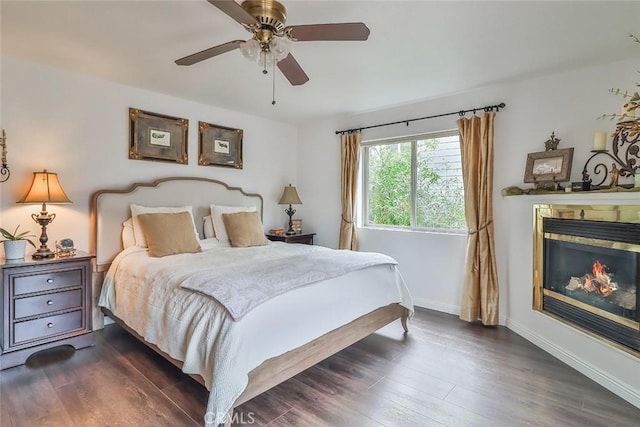 240 Portal St, Oak View, CA 93022 - bedroom featuring dark wood-style flooring, baseboards, a glass covered fireplace, and ceiling fan